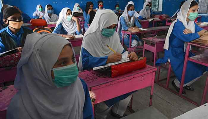 Schoolgirls wearing face masks sitting in a classroom. Source: AFP