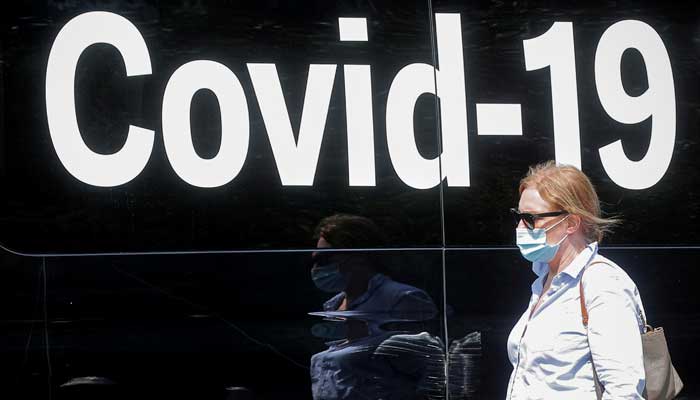 A woman wearing a mask passes by a coronavirus disease mobile testing van, as cases of the infectious Delta variant of COVID-19 continue to rise, in Washington Square Park in New York City, U.S., July 22, 2021. -Reuters