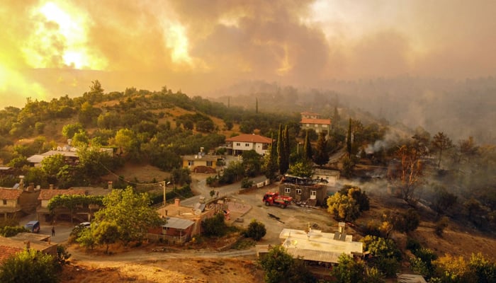 This aerial photograph shows houses surrounded by a wildfire which engulfed a Mediterranean resort region on Turkey´s southern coast near the town of Manavgat, on July 30, 2021. — AFP/File