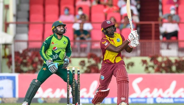 Andre Fletcher (R) of West Indies hits 6 and Mohammad Rizwan (L) of Pakistan watches during the 3rd T20I match between West Indies and Pakistan at Guyana National Stadium in Providence, Guyana on August 1, 2021. — AFP