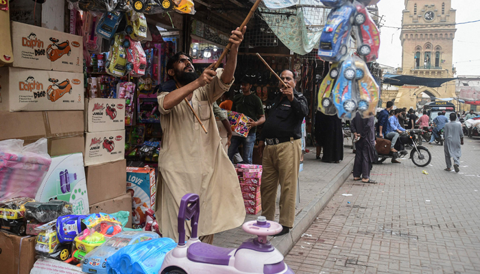 A policeman orders shopkeepers to close their shops after authorities imposed evening lockdowns amidst rising COVID-19 coronavirus cases in Karachi on July 26, 2021 — AFP/File