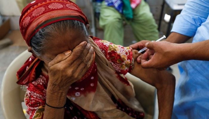 Basanti, 71, reacts as she receives a dose of the coronavirus disease (COVID-19) vaccine at a vaccination center in Karachi, Pakistan June 9, 2021. Photo: Reuters