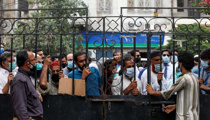 Residents gather to receive a dose of coronavirus disease (COVID-19) vaccine, after government warned of penalties for the unvaccinated, outside a vaccination facility in Karachi, Pakistan August 4, 2021. -REUTERS