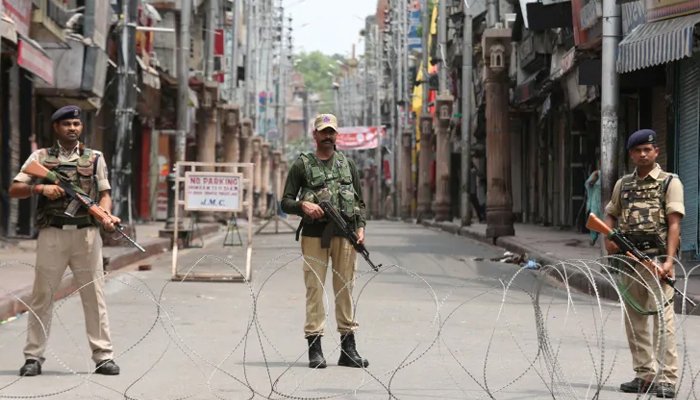 Indian security personnel stand guard along a deserted street during restrictions in Jammu. — Reuters/File