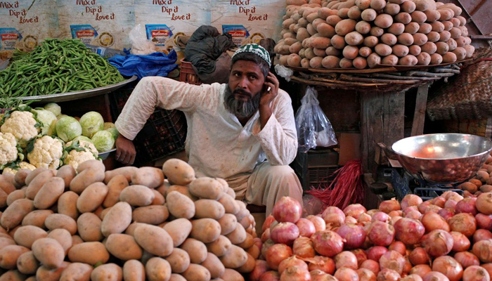 A man selling vegetables waits for customers at his makeshift stall at the Empress Market in Karachi, Pakistan. Photo: Reuters