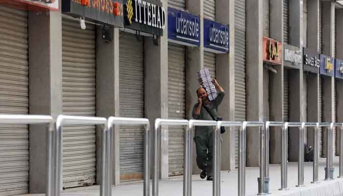 A man walks past a closed market during a partial lockdown after Sindh provincial government decided to shut markets, restaurants, public beaches and discouraged large gatherings to curb the outbreak of the coronavirus disease (COVID-19), in Karachi, Pakistan, July 30, 2021. — Reuters