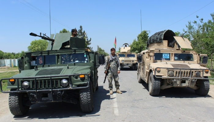 An Afghan security forces member stands beside armoured vehicles in Kunduz. Photo:AFP
