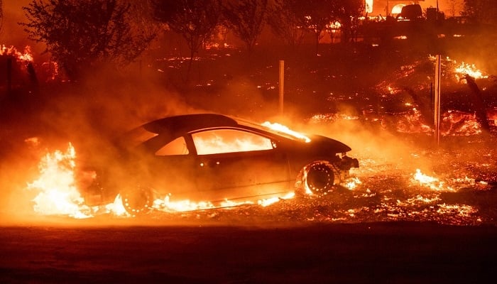 A blaze engulfs a car and the surrounding area in northern California. Photo: AFP
