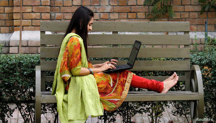 A file photo of a student working on her computer sitting on a bench at a university in Peshawar, Pakistan. Photo: Reuters