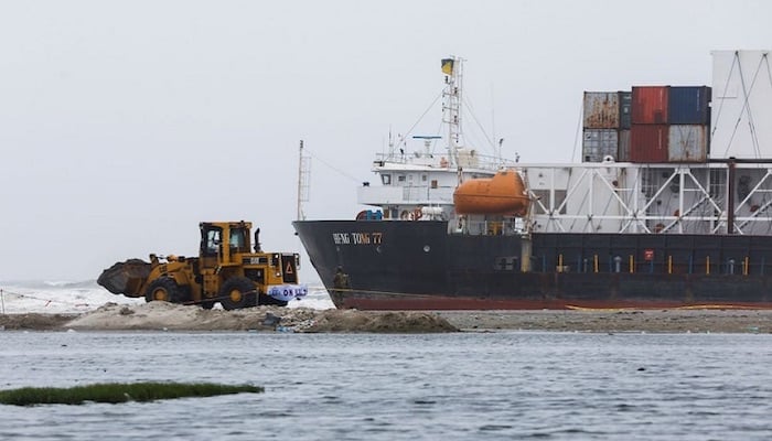A wheel loader clears the ground near stranded cargo ship MV Heng Tong 77 at Sea View beach in Karachi. Photo: Reuters