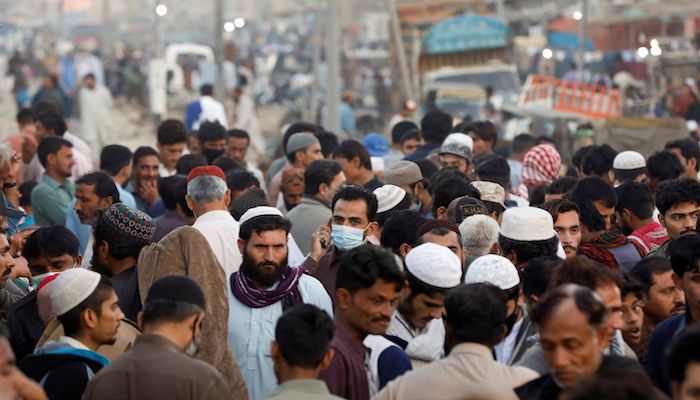 A man wearing a protective mask walks through a crowd of people along a makeshift market as the outbreak of the coronavirus disease (COVID-19) continues, in Karachi, Pakistan January 17, 2021. Photo: Reuters