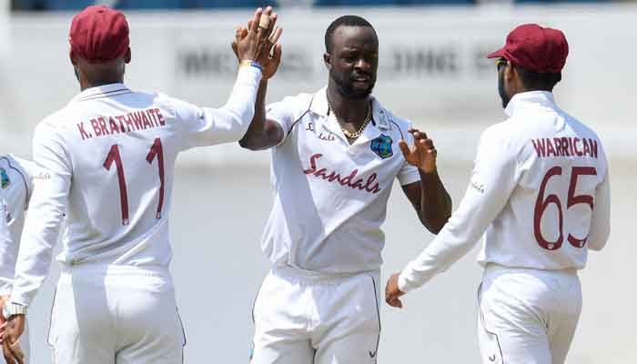 Kemar Roach (2R) of the West Indies celebrates the dismissal of Imran Butt of Pakistan during day 1 of the 1st Test between the West Indies and Pakistan at Sabina Park in Kingston, Jamaica, on August 12, 2021. —Photo by Randy Brooks/AFP