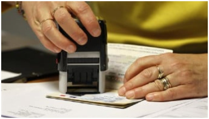 Representational image of a person stamping a passport. Photo: File.