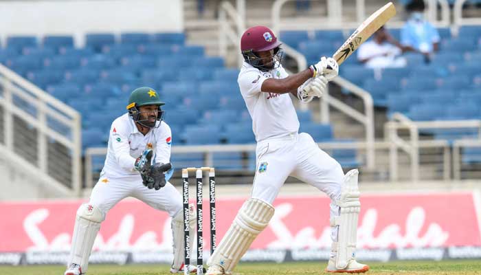 Kraigg Brathwaite (R) of West Indies hits 4 and Mohammad Rizwan (L) of Pakistan watch during day 2 of the 1st Test between West Indies and Pakistan at Sabina Park, Kingston, Jamaica, on August 13, 2021.-AFP