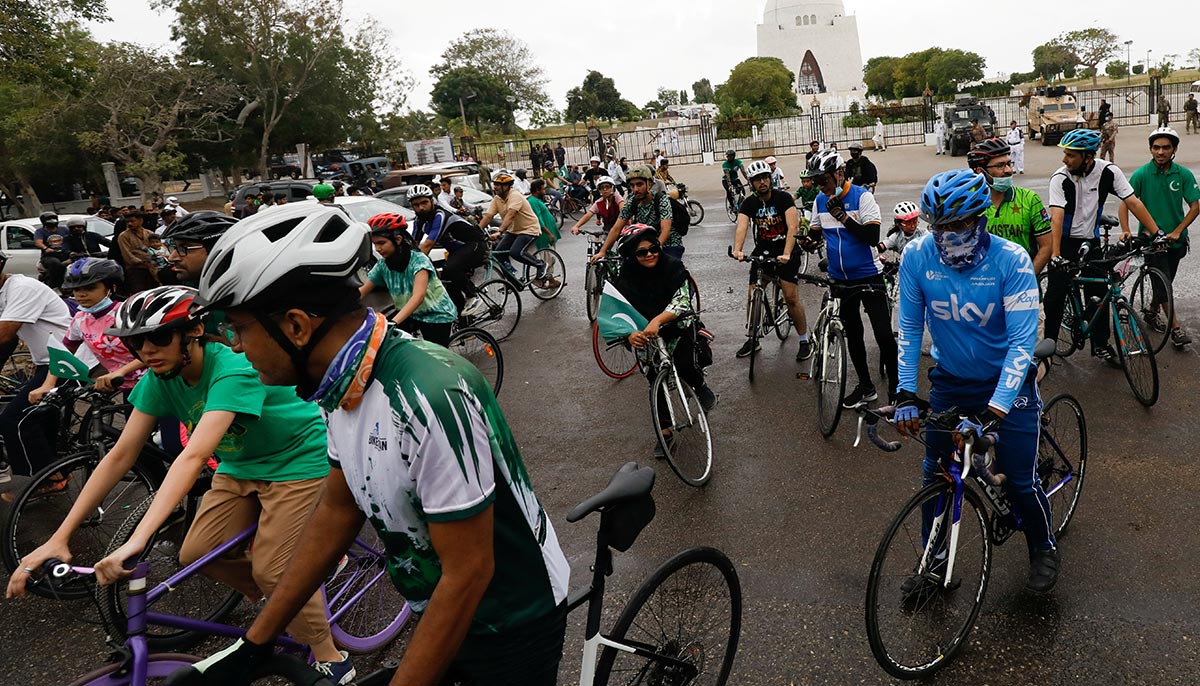 Cyclists pause during the celebration of Independence Day, with the mausoleum of Pakistans founder, Quaid-e-Azam Mohammad Ali Jinnah, in the background, in Karachi, Pakistan August 14, 2021. — Reuters/Akhtar Soomro