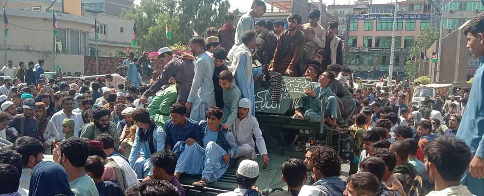 Taliban fighters and local people sit on an Afghan National Army (ANA) humvee vehicle on a street in Jalalabad province on August 15, 2021. — Photo by AFP