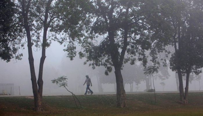 A man wearing a mask on his face walks amid smog at a public park in Lahore, Pakistan November 6, 2017. Photo: Reuters