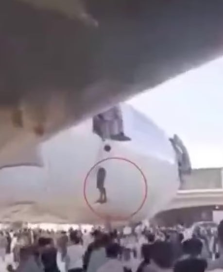 Footage showing desperate Afghans trying to climb onto grounded planes at Kabuls Hamid Karzai airport after the Taliban swept the city. Screengrab via Daily Mail.