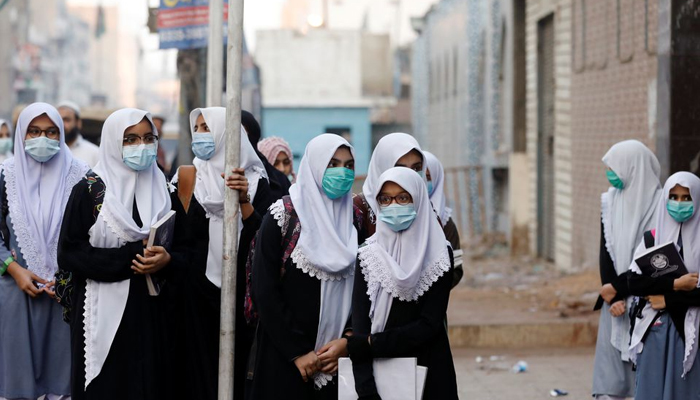 Students gather and wait outside a school building as secondary schools reopen amid the second wave of the coronavirus disease (COVID-19) outbreak, in Karachi, Pakistan January 18, 2021. Photo: Reuters