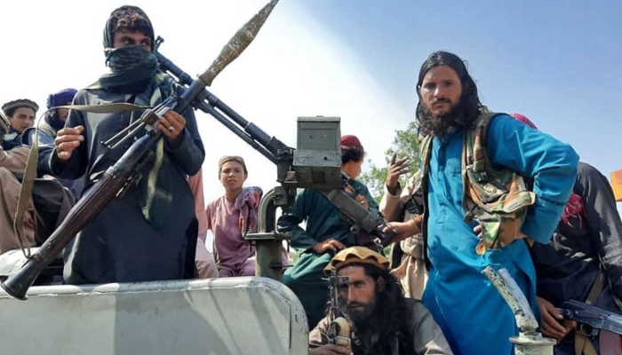 Taliban fighters sit over a vehicle on a street in Laghman province on August 15, 2021. Photo: AFP