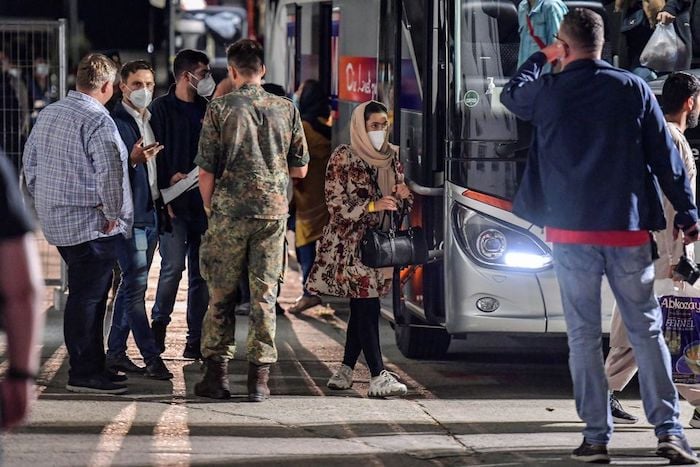 A woman who was evacuated from Kabul, Afghanistan walks with a bag after alighting from a bus upon arriving in Doberlug-Kirchhain, Germany, August 20, 2021. Photo: Reuters