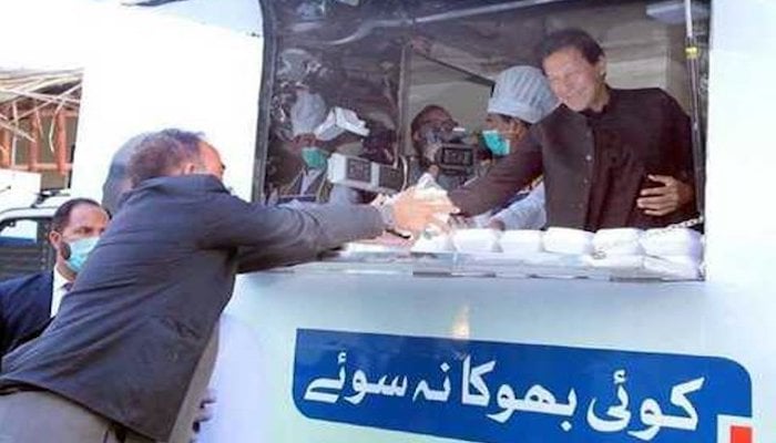 In a file photo, Prime Minister Imran Khan distributes free meals from the Ehsaas Koi Bhooka Na Soye truck kitchen. Photo: APP