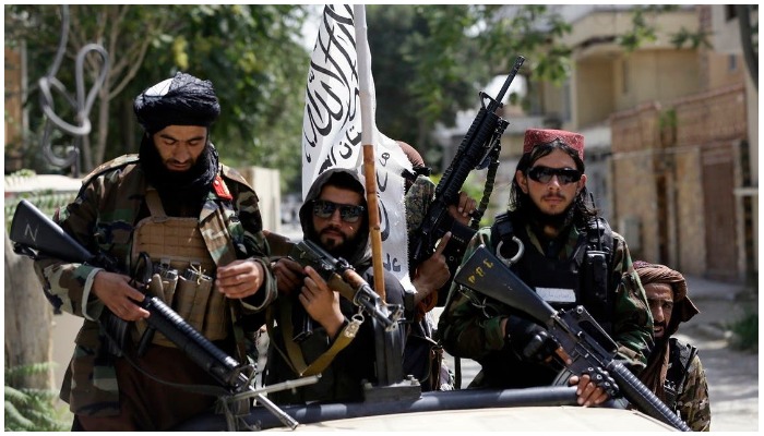 Taliban fighters display their flags on patrol in Kabul. Photo AP