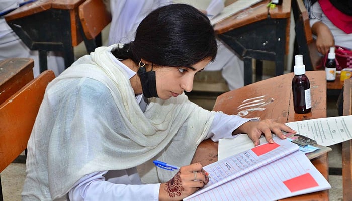 Student solving a question paper during the annual examination of HSC (part-II) at Hayat Girls High School in Hyderabad, on July 26, 2021. — APP/File