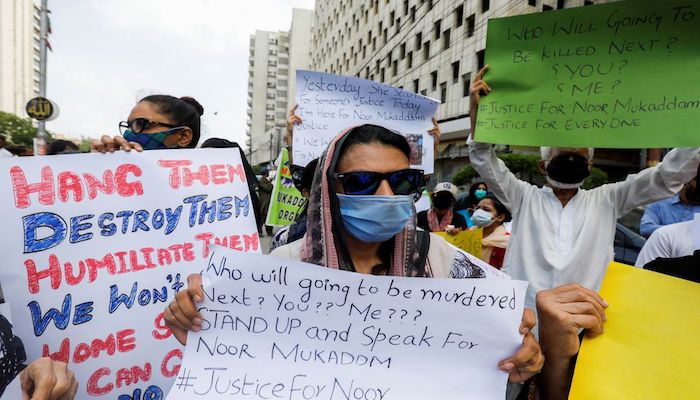 People carry signs against the killing of Noor Mukadam, 27, daughter of former Pakistani diplomat, and to condemn the violence against women and girls during a protest in Karachi, Pakistan July 25, 2021. Photo: Reuters
