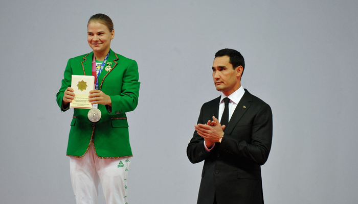 Turkmenistans first-ever Olympic medallist, weightlifter Polina Guryeva (L) receives presents from Honoured Coach of Turkmenistan Serdar Berdymukhamedov, the 39-year-old son of the countrys leader, during a ceremony in the capital Ashgabat, on August 21, 2021. — AFP