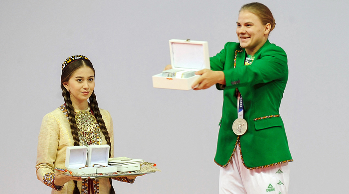Turkmenistans first-ever Olympic medallist, weightlifter Polina Guryeva (R) receives presents during a ceremony in the capital Ashgabat, on August 21, 2021. — AFP