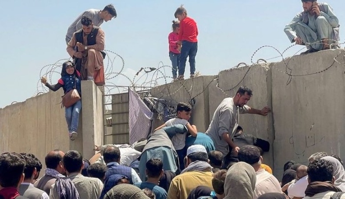 A man pulls a girl to get inside Hamid Karzai International Airport in Kabul, Afghanistan on August 16, 2021. Reuters