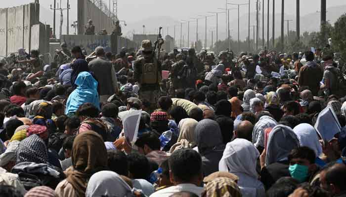 Afghans gather on a roadside near the military part of the airport in Kabul on August 20, 2021, hoping to flee from the country after the Talibans takeover of Afghanistan. — Photo by Wakil Kohsar/AFP