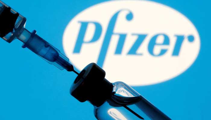 A vial and syringe are seen in front of a displayed Pfizer logo in this illustration taken January 11, 2021. — Reuters/Dado Ruvic/Illustration