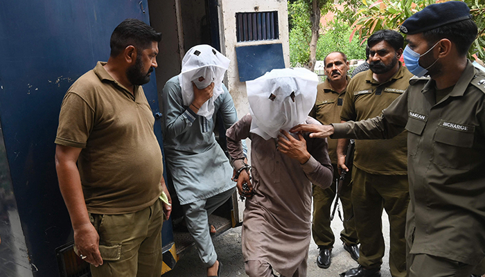 Policemen escort men as they are brought to a local court for for allegedly groping and harassing a female TikToker in a public park on the eve of Pakistan´s Independence Day, in Lahore on August 21, 2021. — AFP/File