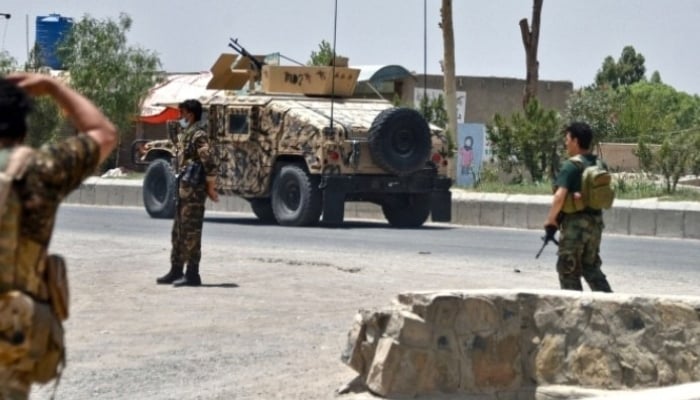 Afghan security personnel stand guard along the road amid fighting between Afghan security forces and Taliban fighters in Kandahar on July 9. Photo: AFP