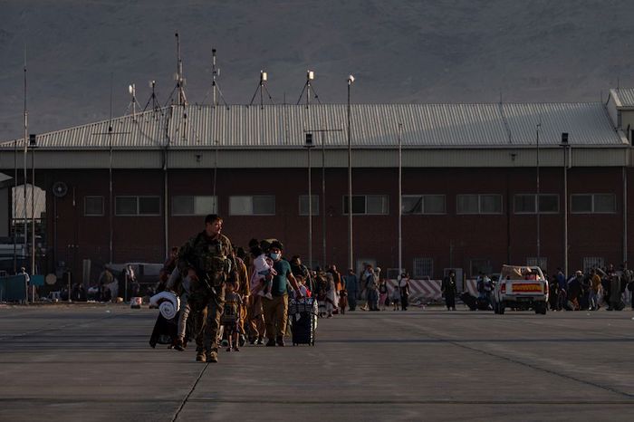 A U.S. Air Force Airman guides qualified evacuees aboard a U.S. Air Force C-17 Globemaster III at Hamid Karzai International Airport (HKIA), Afghanistan, August 24, 2021. U.S. Air Force/Senior Airman Taylor Crul/Handout via REUTERS