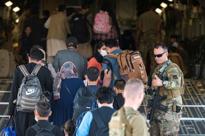 U.S. Air Force Airmen guide qualified evacuees aboard a U.S. Air Force C-17 Globemaster III at Hamid Karzai International Airport (HKIA), Afghanistan, August 24, 2021. U.S. Air Force/Senior Airman Taylor Crul/Handout via REUTERS