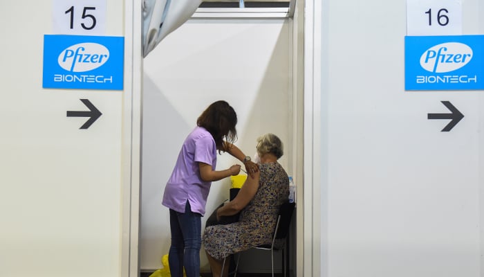 A healthcare worker administers the third dose of Pfizers coronavirus disease (COVID-19) vaccine to a woman at Belgrade Fair vaccination centre in Belgrade, Serbia, August 25, 2021. — Reuters