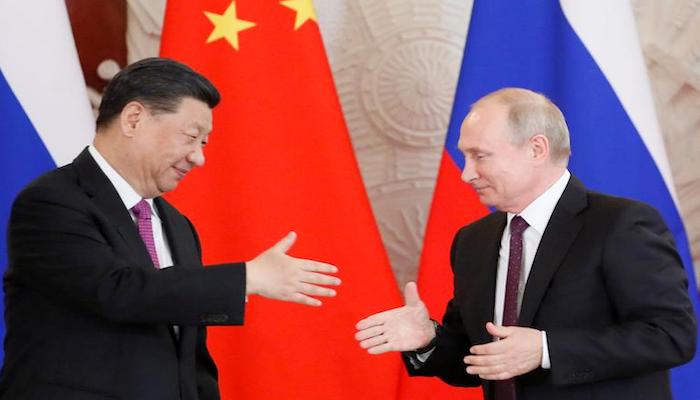 Russian President Vladimir Putin attempts to shake hands with his Chinese counterpart Xi Jinping during a meeting in Moscow, Russia, June 5, 2019. Photo: Reuters
