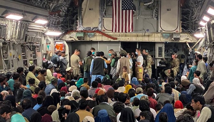 A newborn baby is looked after prior taking off with other Afghan evacuees on a C-17 Globemaster III at a Middle East staging area August 23, 2021. — Reuters