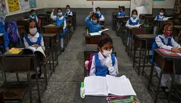 Students of a school in Karachi listen to a lecture wearing face masks. — AFP/File