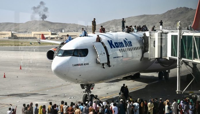 Afghans throng an airplane at Kabul airport. Photo: AFP