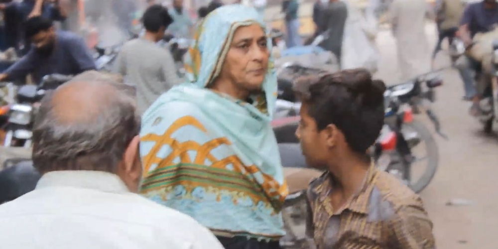 Jameela Khatoon speaks to nearby shopkeepers at a busy road in Ranchor Line.