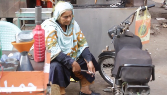 Wrench in hand, Jameela Khatoon works tediously on a motorcycle.