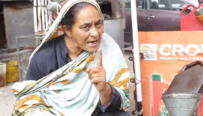 Jameela Khatoon gestures as she speaks beside her makeshift oil shop.