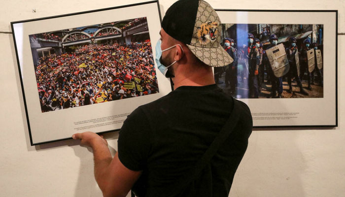 Seorang pekerja menggantung foto untuk pameran Fotografer anonim di Myanmar menjelang festival foto jurnalistik internasional Visa pour lImage di Perpignan, Prancis.  AFP