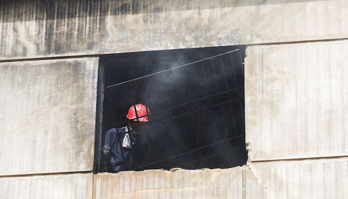 A firefighter removes an iron grill window, after a fire broke out at a multi-storey chemical factory, in Karachi, Pakistan, August 27, 2021. Photo: Reuters
