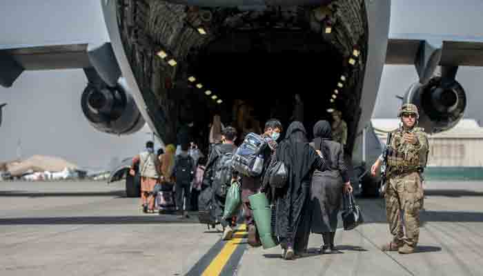 In this handout image courtesy of the US Marine Corps, Families begin to board a US Air Force Boeing C-17 Globemaster III during an evacuation at Hamid Karzai International Airport, Kabul, Afghanistan, August 23, 2021.-AFP