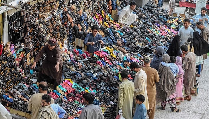 Sellers line up for shoes at a market in Pakistan. Photo: AFP